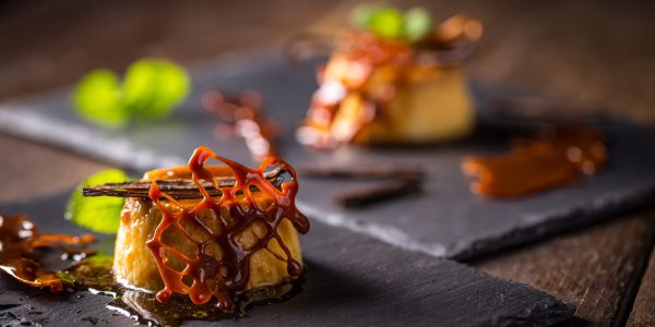 Caramel pudding dessert with vanilla, mint and caramel decoration